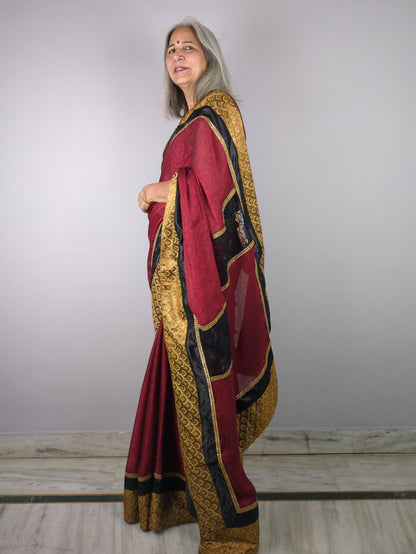 Woman wearing a traditional outfit with red, gold, and black colors on a plain background