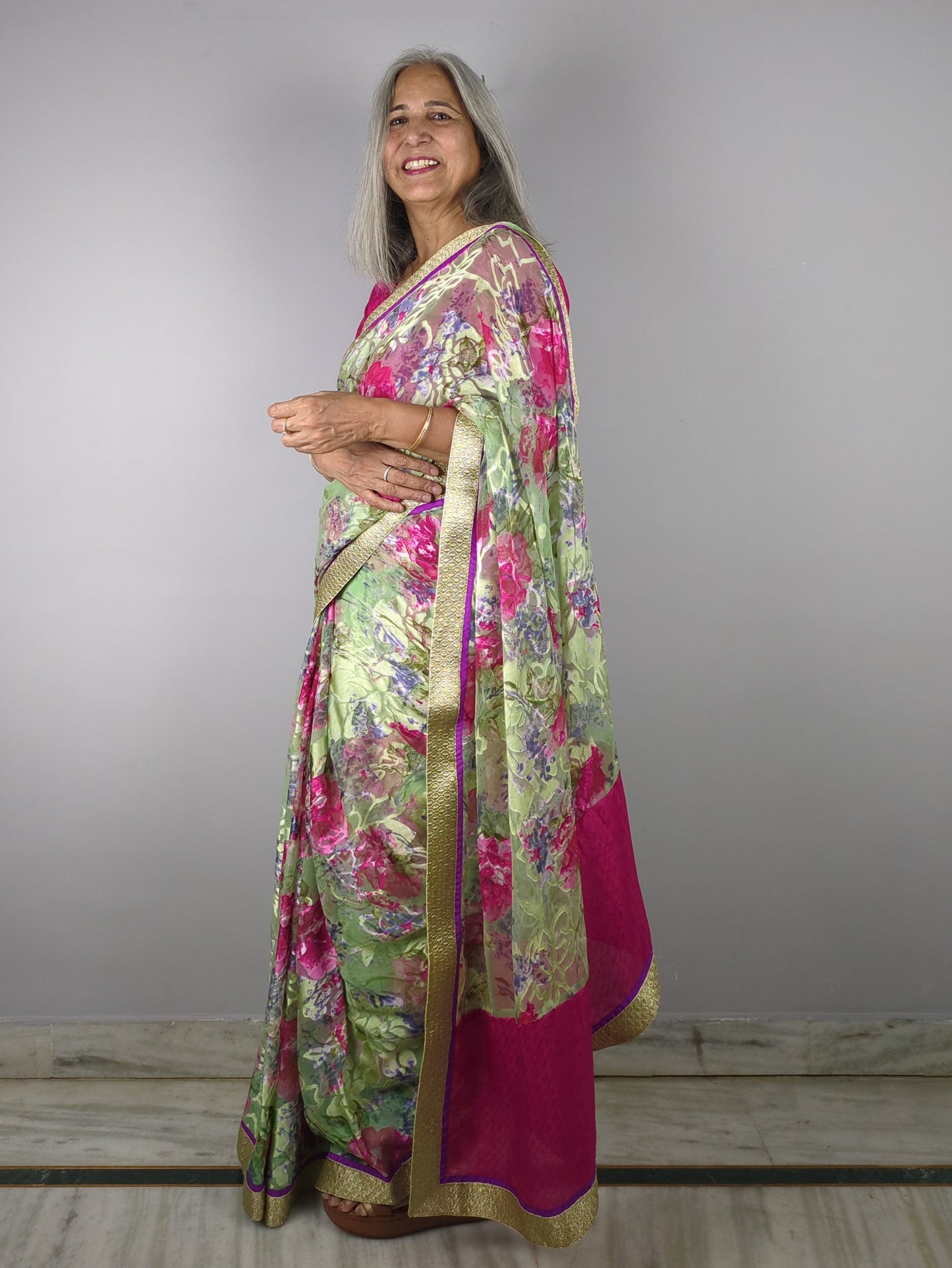 Woman wearing a floral dress pink saree on a gray background