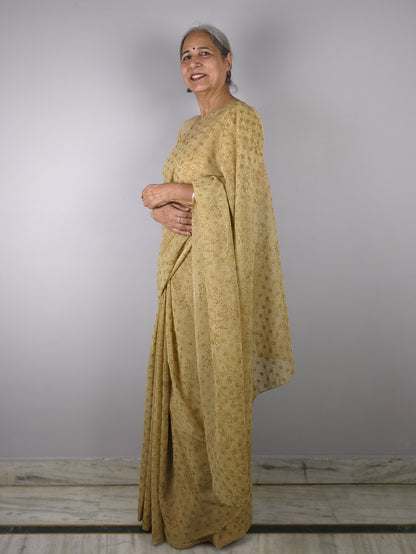 Person wearing a yellow traditional outfit against a plain background