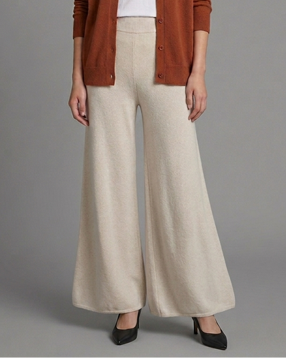Woman wearing beige wide-leg pants on a gray background