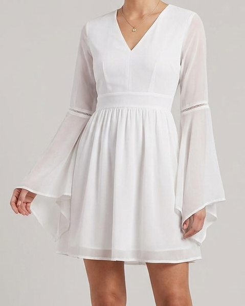 Woman wearing a white dress with long sleeves on a plain background