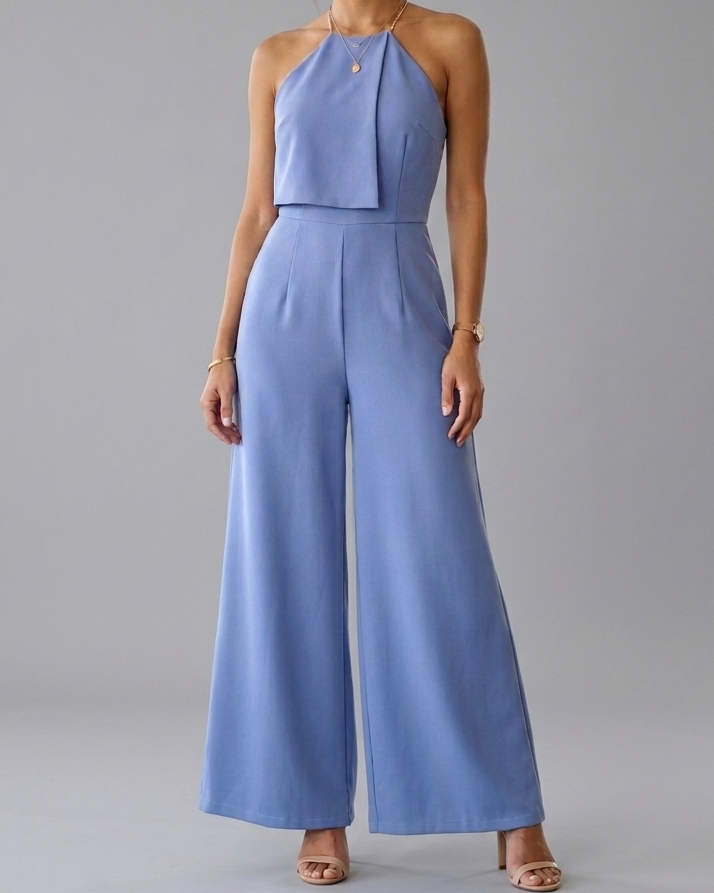 Woman wearing a blue jumpsuit against a gray background