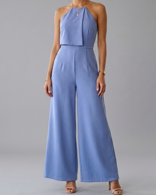 Woman wearing a blue jumpsuit against a gray background