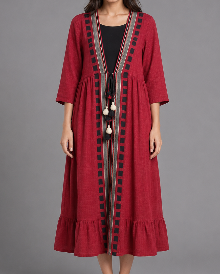 Woman wearing a red dress with black embroidery on a gray background