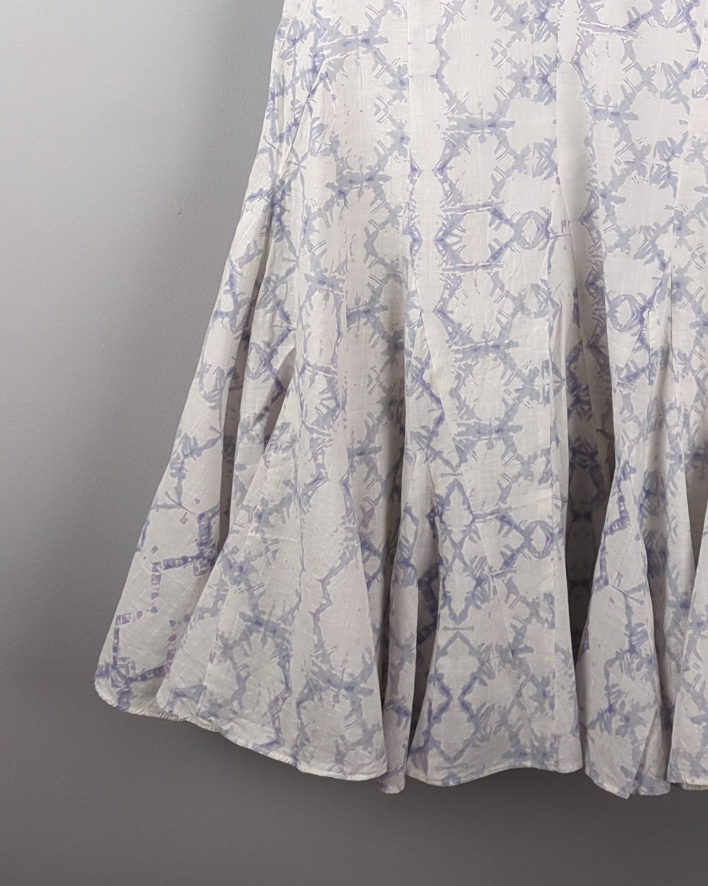 Delicate cotton dress made with Shibori style light indigo dye. The dress has a feminine silhouette and shows the bottom flair of the dress