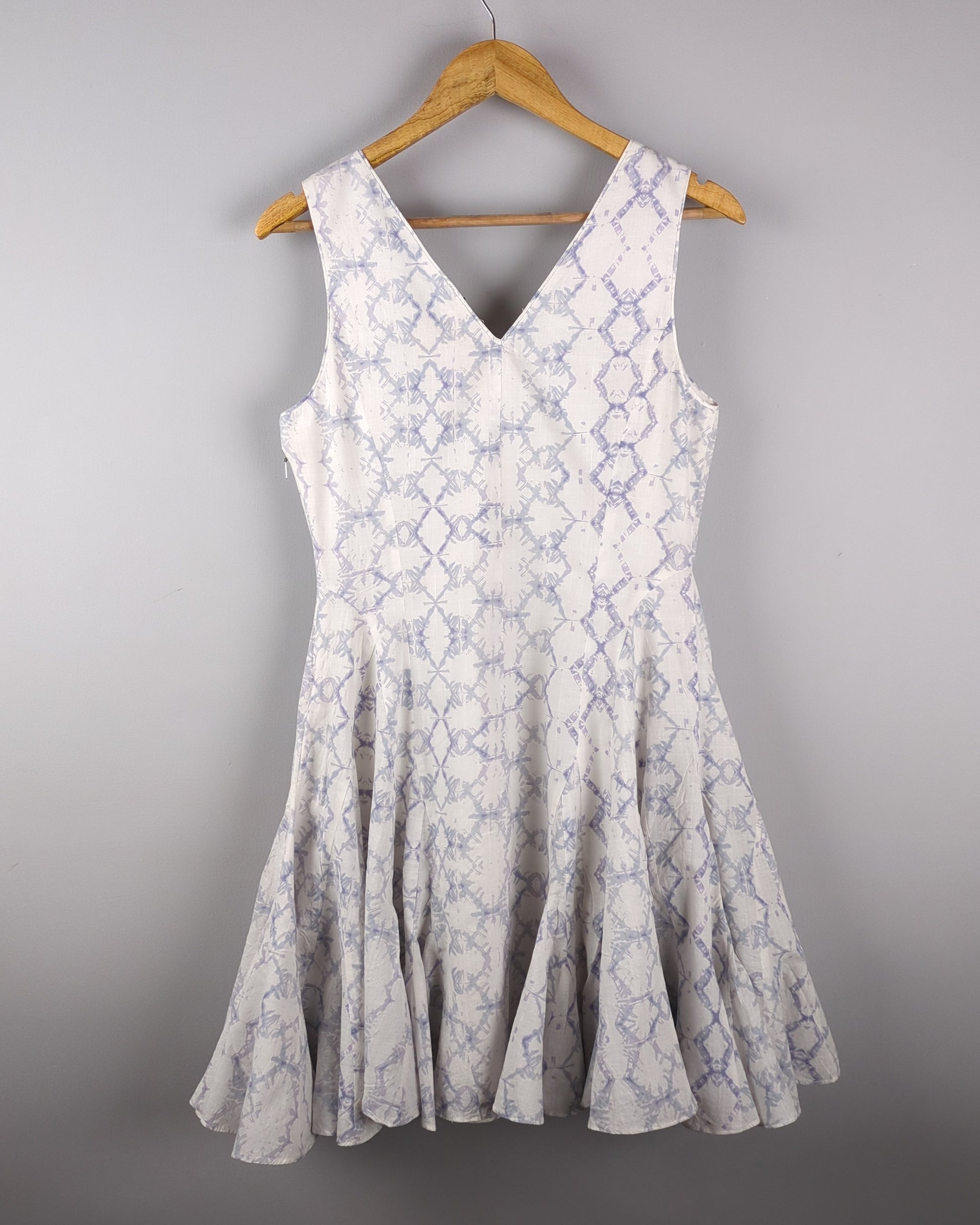 Delicate cotton dress made with Shibori style light indigo dye. The dress has a feminine silhouette and shows the backside of the dress