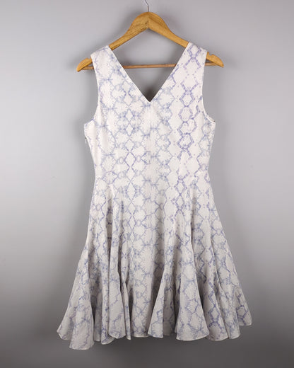 Delicate cotton dress made with Shibori style light indigo dye. The dress has a feminine silhouette and shows the backside of the dress
