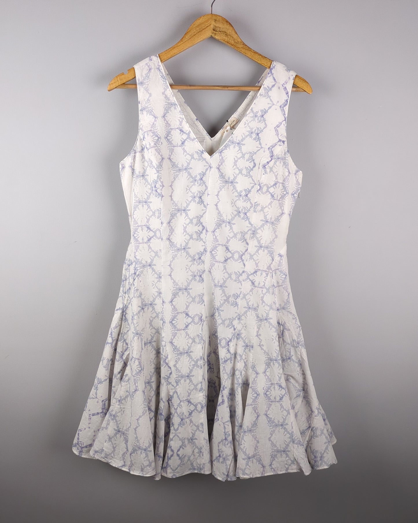 Delicate cotton dress made with Shibori style light indigo dye. The dress has a feminine silhouette and shows the entire front of the dress