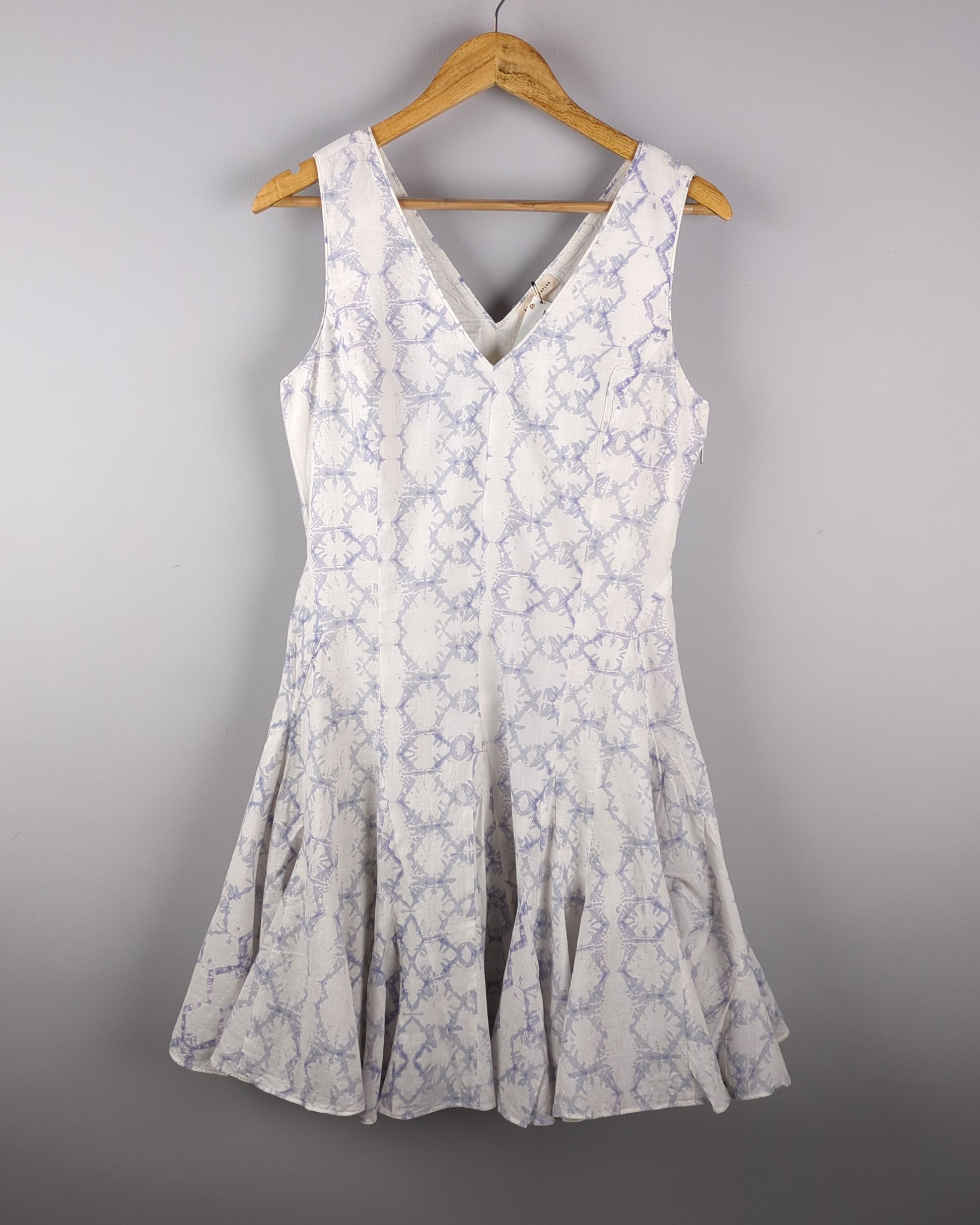 Delicate cotton dress made with Shibori style light indigo dye. The dress has a feminine silhouette and shows the entire front of the dress