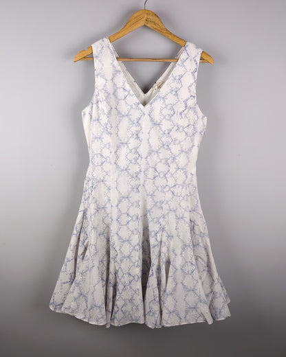 Delicate cotton dress made with Shibori style light indigo dye. The dress has a feminine silhouette and shows the entire front of the dress